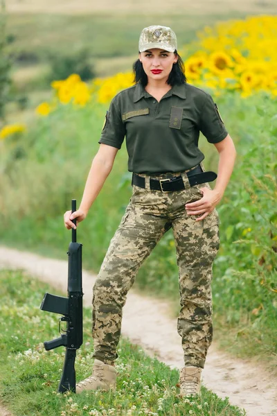 Soldier woman in military uniform. A girl in a military uniform with a weapon.