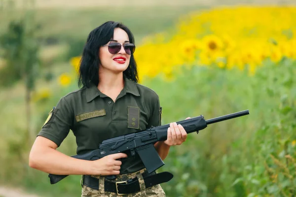 Soldier woman in military uniform. A girl in a military uniform with a weapon.