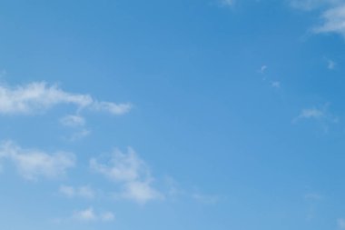 Blue sky background and white clouds soft focus, pastel sky. The moon is high in the sky