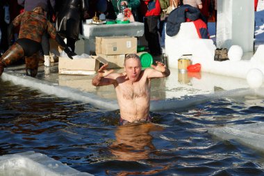 Ukraine, the city of Romny, January 19, 2022: the feast of the Baptism of the Lord. Orthodox rite of bathing in the ice hole. Epiphany. Many people come to swim in the winter river.