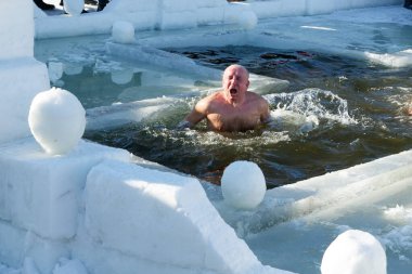 Ukraine, the city of Romny, January 19, 2022: the feast of the Baptism of the Lord. Orthodox rite of bathing in the ice hole. Epiphany. Many people come to swim in the winter river.