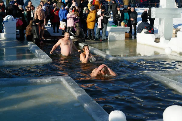 Ukraine, the city of Romny, January 19, 2022: the feast of the Baptism of the Lord. Orthodox rite of bathing in the ice hole. Epiphany. Many people come to swim in the winter river.