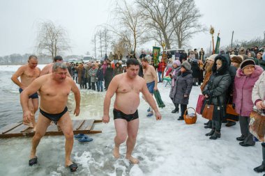 Ukraine, the city of Romny, January 19, 2013: the feast of the Baptism of the Lord. Orthodox rite of bathing in the ice hole. Epiphany. Many people come to swim in the winter river