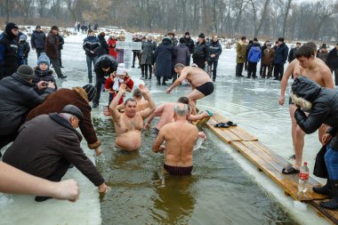 Ukraine, the city of Romny, January 19, 2013: the feast of the Baptism of the Lord. Orthodox rite of bathing in the ice hole. Epiphany. Many people come to swim in the winter river