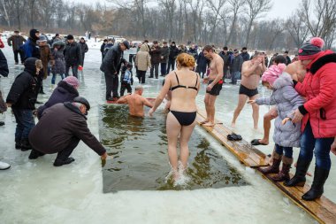 Ukraine, the city of Romny, January 19, 2013: the feast of the Baptism of the Lord. Orthodox rite of bathing in the ice hole. Epiphany. Many people come to swim in the winter river