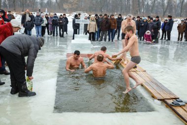 Ukraine, the city of Romny, January 19, 2013: the feast of the Baptism of the Lord. Orthodox rite of bathing in the ice hole. Epiphany. Many people come to swim in the winter river