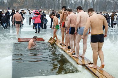 Ukraine, the city of Romny, January 19, 2013: the feast of the Baptism of the Lord. Orthodox rite of bathing in the ice hole. Epiphany. Many people come to swim in the winter river