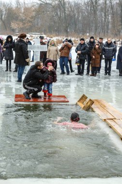 Ukraine, the city of Romny, January 19, 2013: the feast of the Baptism of the Lord. Orthodox rite of bathing in the ice hole. Epiphany. Many people come to swim in the winter river