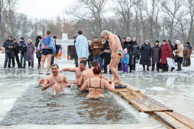 Ukraine, the city of Romny, January 19, 2013: the feast of the Baptism of the Lord. Orthodox rite of bathing in the ice hole. Epiphany. Many people come to swim in the winter river