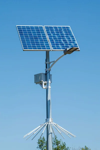 Mavi gökyüzü arka planda sokak lambası ile Güneş cihazı. Sokak ışığı pil dahil güneş paneli tarafından desteklenmektedir. Güneşten alternatif enerji.
