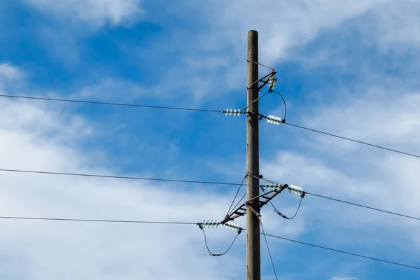 Mavi gökyüzünün arka planında yakın plan elektrik hatları var. Direkte elektrik merkezi. Yüksek voltaj kabloları.