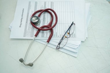 Drug test report, Medical stethoscope with the clipboard, and eyeglass