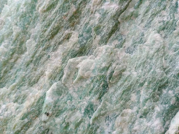 Close-up of  green jade and other minerals in an uncut stone