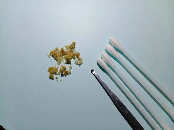 Earpick, ear wax, and cotton swabs On the light blue tabletop
