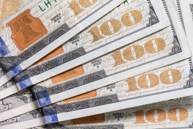 Yüz dolarlık banknotlar beyaz arka planda çekiliyor.