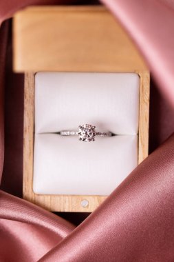 Pembe kumaşlı bir kutuda elmas evlilik ya da nişan yüzüğü