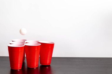 Kırmızı bardaklar beyaz arka planda bira içme oyunu için hazırlanıyor.