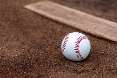 Beyzbol atıcının tümseğindeki çamurda yatıyordu.