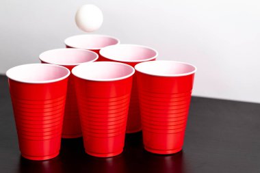 Kırmızı bardaklar beyaz arka planda bira içme oyunu için hazırlanıyor.