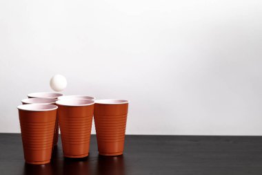 Kırmızı bardaklar beyaz arka planda bira içme oyunu için hazırlanıyor.