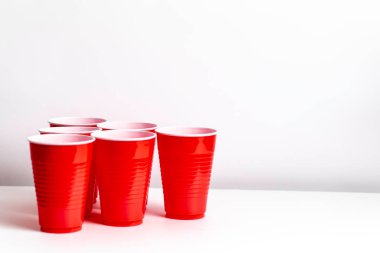 Kırmızı bardaklar beyaz arka planda bira içme oyunu için hazırlanıyor.