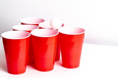 Kırmızı bardaklar beyaz arka planda bira içme oyunu için hazırlanıyor.