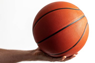 Beyaz arka planda elinde basketbol topu tutan bir erkek.
