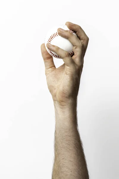 A baseball being tossed from a hand on a white background