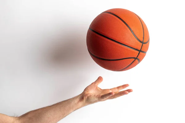 Male tossing a basketball in his hand on a white backgroun