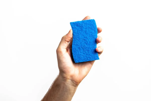 Blue cleaning sponge in a hand against a white background