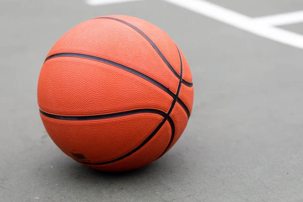 Basketball on the ground at an outdoor court at a park