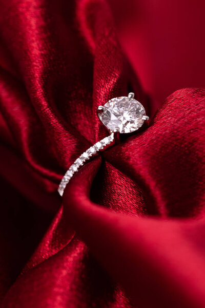 Diamond wedding or engagement ring on red fabric