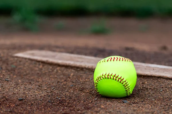 Softball laying in the dirt at the pitcher's mound