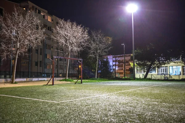 Futsal, small soccer or football field in a park at night with lights