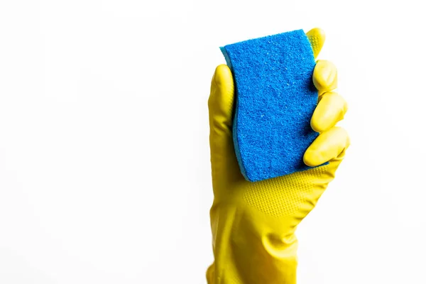 Blue cleaning sponge in a hand against a white background