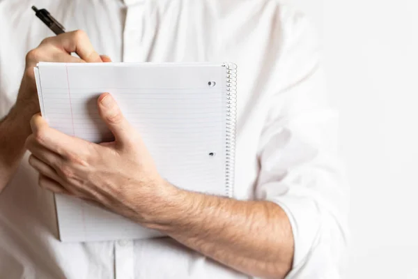 Professional young adult writing or taking notes on a notepad