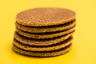 Stroopwafel cookies or biscuits on a gold or yellow background