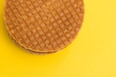 Stroopwafel cookies or biscuits on a gold or yellow background