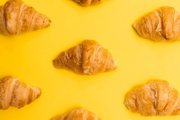 Croissants in a pattern across a surface that is yellow