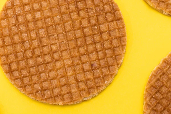 Stroopwafel cookies or biscuits on a gold or yellow background