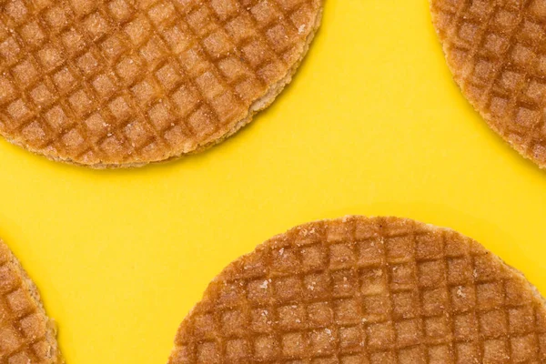 Stroopwafel cookies or biscuits on a gold or yellow background