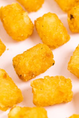Tater tots laid out on a white background