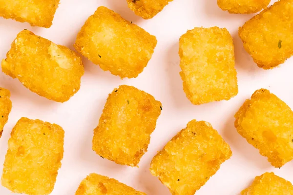 Tater tots laid out on a white background