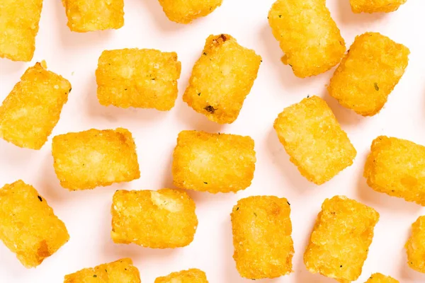 Tater tots laid out on a white background