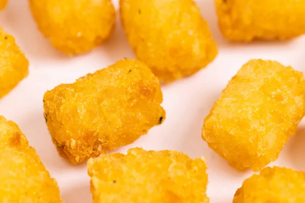 Tater tots laid out on a white background