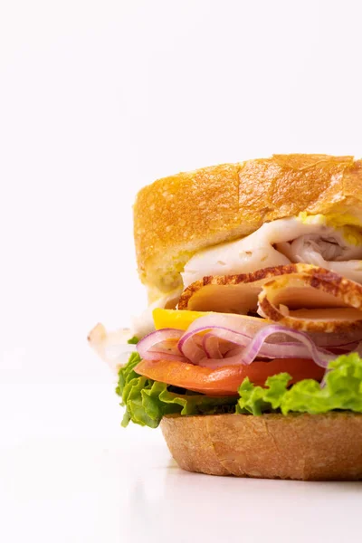 Freshly made sandwich with turkey, tomato, lettuce, and onion