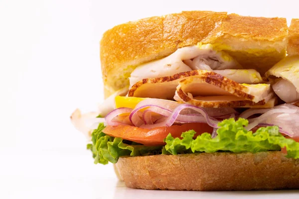 Freshly made sandwich with turkey, tomato, lettuce, and onion