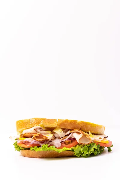Freshly made sandwich with turkey, tomato, lettuce, and onion