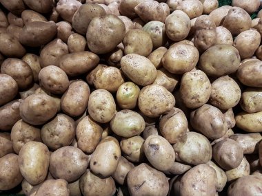 Geleneksel bir süpermarkette yatağa yayılmış bir avuç patates yukarıdan fotoğraflanmış.