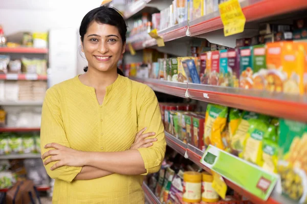 Woman with shopping trolley in supermarket.